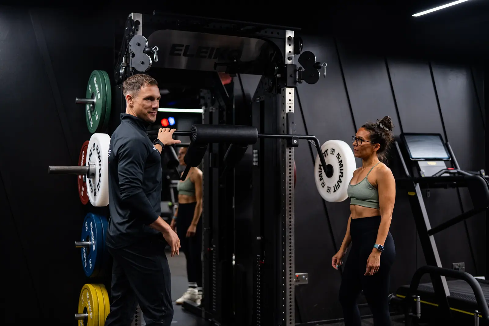 Jools Newsome coaching a client at the Eleiko rack in a private coaching gym.